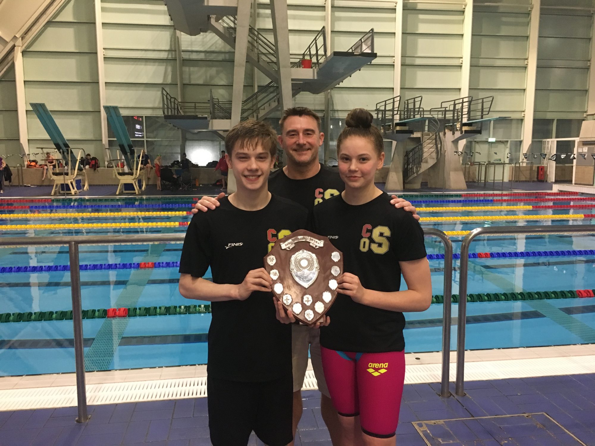 John with two of his swimmers, holding the trophy for Lancashire Top Club, which City of Salford Swimming Club won earlier this year