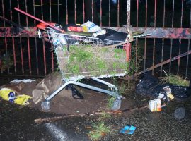 A discarded shopping kart filled with rubbish