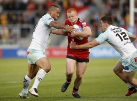 Salford Red Devils' Josh Wood is tackled by Widnes Vikings Weller Hauraki (left) and Matt Whitley (right) during the Super League match at the AJ Bell Stadium, Salford.b Photo credit: PA