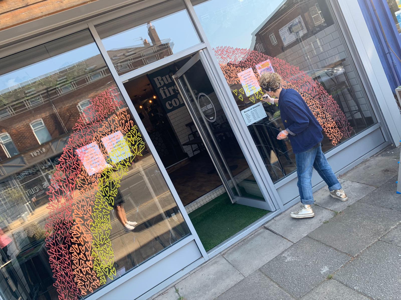 Emma working on her window art at The Coffee House & Kitchen. Image credit: Emma Evans