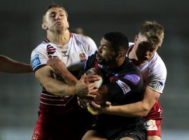 Salford Red Devils' Kallum Watkins (centre) is tackled by Wigan Warriors' Joe Greenwood (left) and Morgan Smithies during the Betfred Super League match at the Totally Wicked Stadium, St Helens.