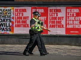 GLASGOW, SCOTLAND - MAY 06: Two police officers walk past posters on Sauchiehall Street during the coronavirus lockdown on May 6, 2020 in Glasgow, Scotland.  The country continues quarantine measures intended to curb the spread of Covid-19, but the infection rate is falling, and government officials are discussing the terms under which it would ease the lockdown. (Photo by Jeff J Mitchell/Getty Images)