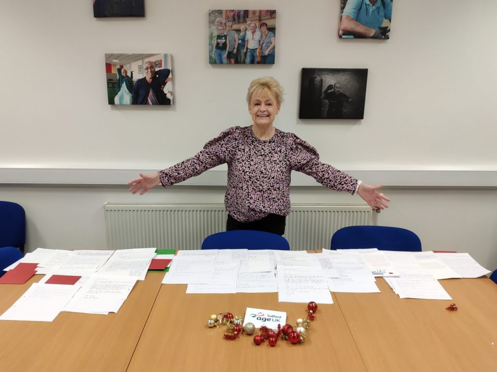 Age UK Salford's Home Services Coordinator distributing letters image.