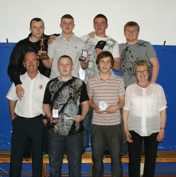 Alfrieda Kindon with a group of rugby players with awards
