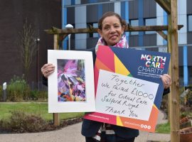 Artist Susan Aggarwal with one of her prints entitled ‘A Rainbow of Flowers Our NHS’, which she sold to help
raise £1,000 for the Critical Care Unit at Salford Royal.