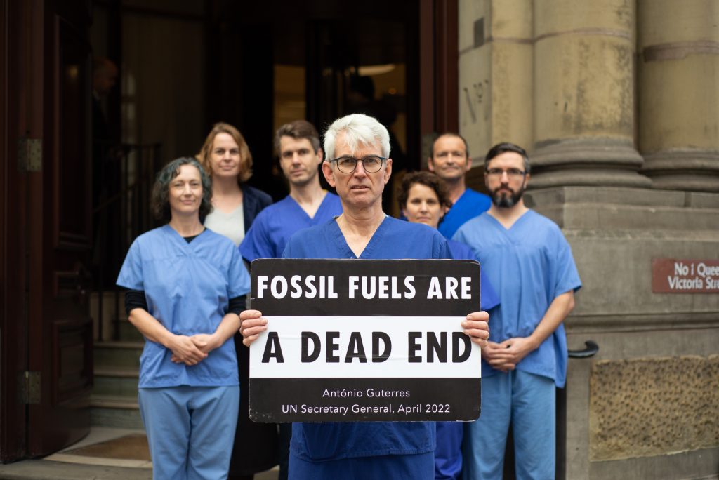 David McKelvey with his colleagues and a sign saying "Fossil fuels are a dead end" during his protest at Lambeth Bridge