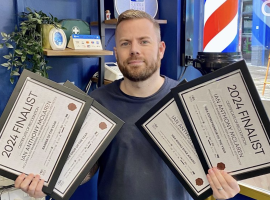 Ian McLaren holding his finalist certificates. Photo courtesy of Ian McLaren.