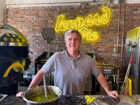 Tony Elliott, in front of a neon yellow Leopard Pie sign. Taken by Kyle Somerville.