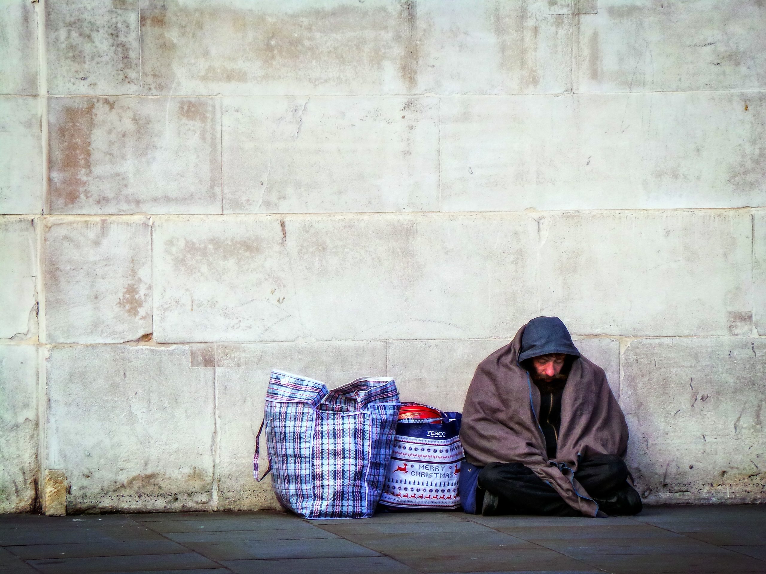 homeless by a wall