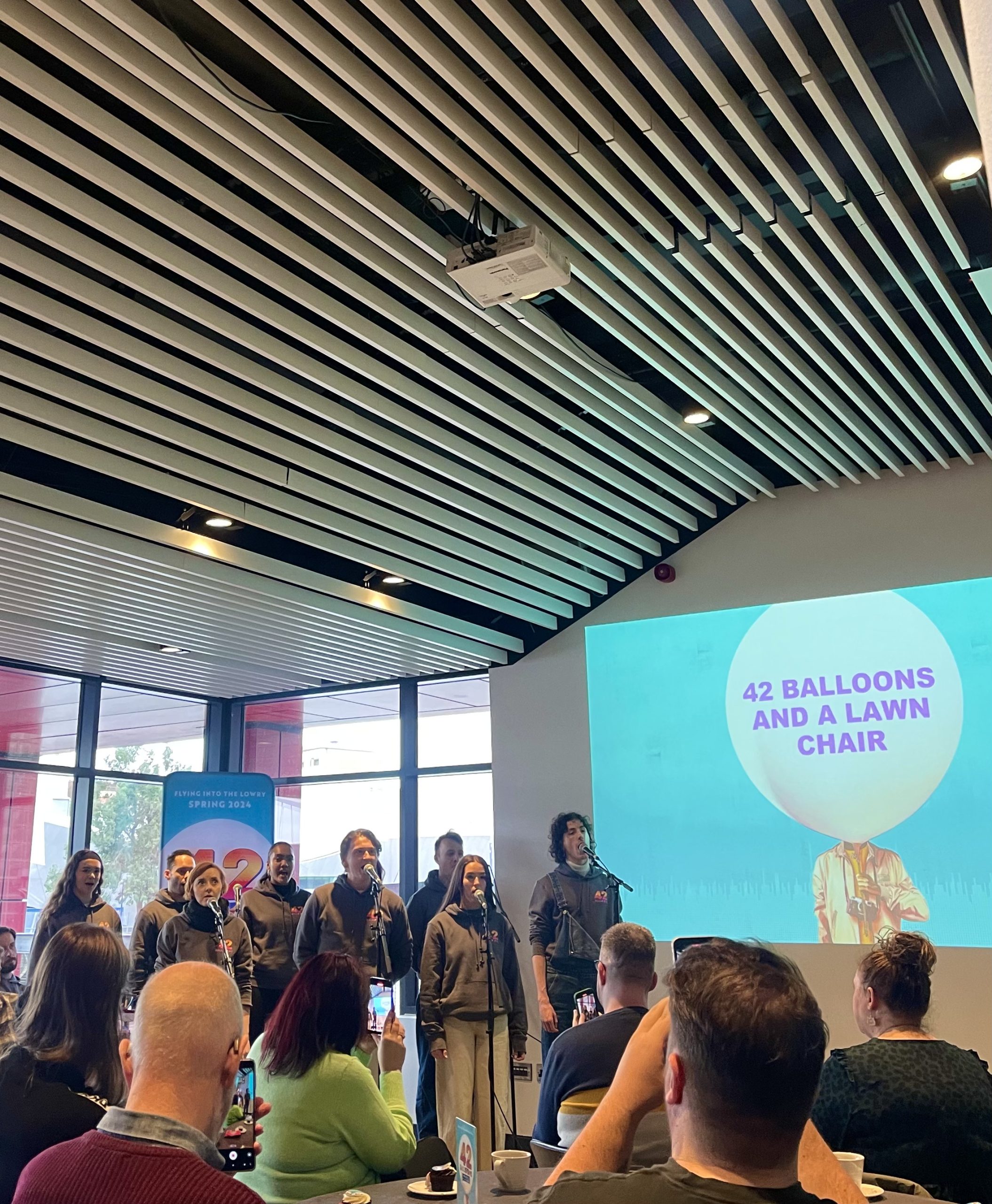 Cast members singing at The Lowry 