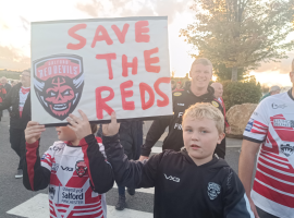 "Save The Reds" - Young Salford Red devils fan holds sign at the 1873 protest