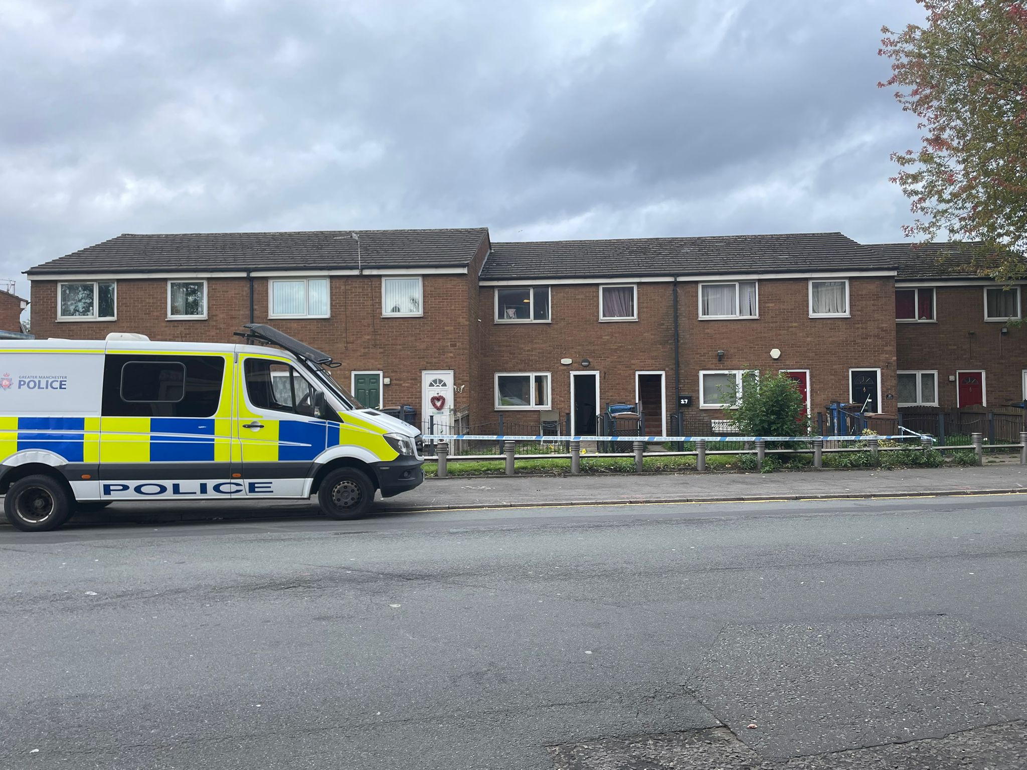 Police scene in Salford neighbourhood after shooting leaves bullet holes in windows