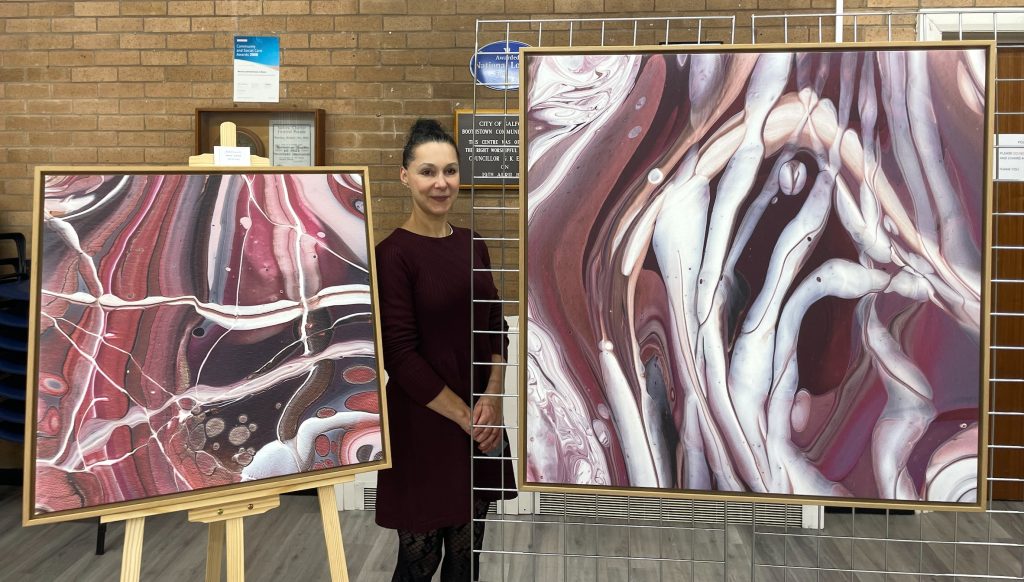 Artist Nadya Lamar with her paintings at Boothstown Community Centre
